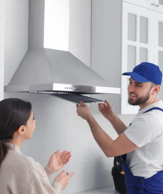A kitchen hood repairing expert discusiing the issues of kithen hood with a women.
